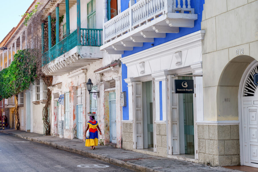 A local lady walks towards the center of town to pose for tourists in traditional dress